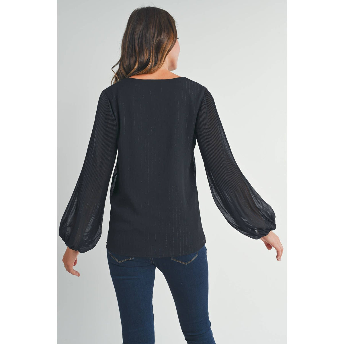 Back view of a woman wearing the black long sleeve maternity blouse with sheer balloon sleeves
