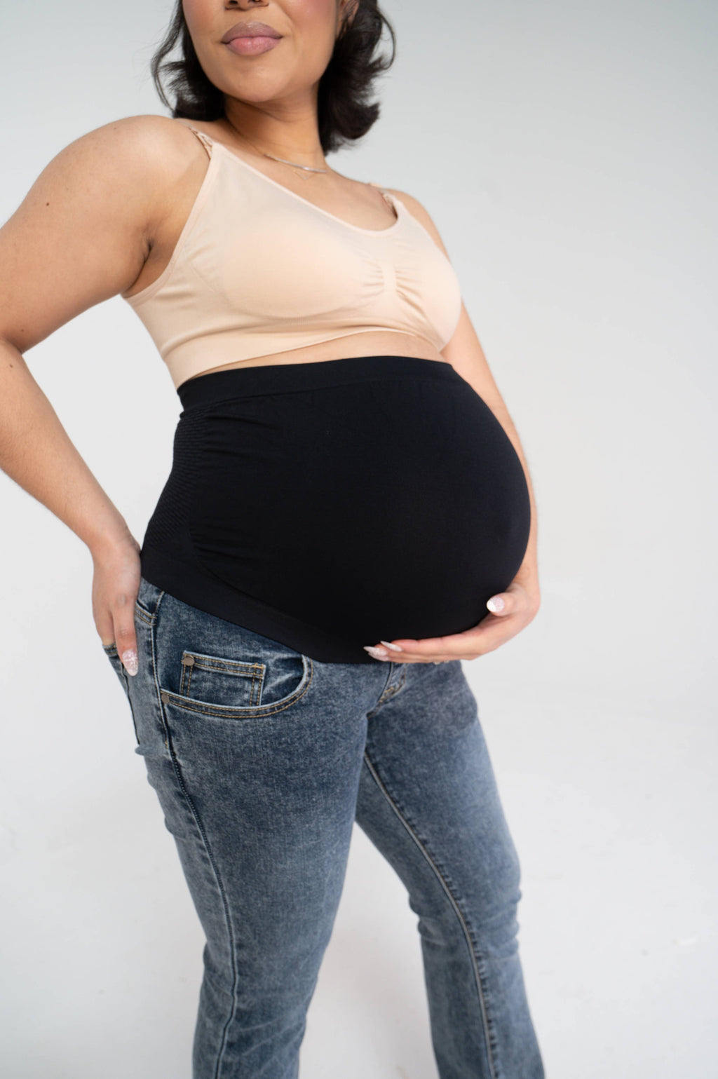 Close-up of the maternity jeans' black stretchy over-the-belly panel worn over the pregnant belly